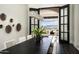Dining room with mountain views through open doors, a long black table, and seating for eight at 6112 E Quartz Mountain Rd, Paradise Valley, AZ 85253