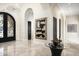 Elegant foyer with marble floors, chandelier, arched doorways, and a decorative glass table at 6112 E Quartz Mountain Rd, Paradise Valley, AZ 85253