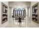 Grand foyer with pillars, arched doorways, marble floors, and views into the living room at 6112 E Quartz Mountain Rd, Paradise Valley, AZ 85253
