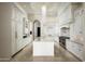 Bright kitchen features an island, white cabinetry, stone countertops and stainless appliances at 6112 E Quartz Mountain Rd, Paradise Valley, AZ 85253