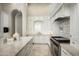 Bright kitchen features an island, white cabinetry, stone countertops and stainless appliances at 6112 E Quartz Mountain Rd, Paradise Valley, AZ 85253