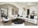 Open-concept living room features an arched entryway, modern furniture, and tile floors at 6112 E Quartz Mountain Rd, Paradise Valley, AZ 85253
