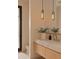 Modern bathroom with stone countertop, wood cabinets, vessel sink, pendant lighting, and stone floors at 36421 N 105Th Pl, Scottsdale, AZ 85262