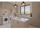 Bright laundry room features modern washer and dryer, center island, and ample cabinet storage at 36421 N 105Th Pl, Scottsdale, AZ 85262