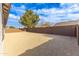 Backyard with gravel, block fence, and a mature tree at 17463 N 66Th Ave, Glendale, AZ 85308