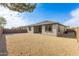 View of the backyard with rock landscaping, block fence, patio, and home at 17463 N 66Th Ave, Glendale, AZ 85308