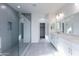 A bright bathroom with a shower, double vanity, and access to the walk-in closet at 17463 N 66Th Ave, Glendale, AZ 85308