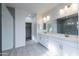 Bathroom featuring a double vanity, walk-in shower, and entry to the walk-in closet at 17463 N 66Th Ave, Glendale, AZ 85308