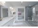 A bright, open bathroom with double vanity, gray tiled shower, and hallway access at 17463 N 66Th Ave, Glendale, AZ 85308