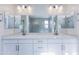 An elegant bathroom with double sinks, large mirrors, quartz counters and modern fixtures at 17463 N 66Th Ave, Glendale, AZ 85308