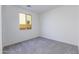 An empty bedroom with light gray carpet and one large window with a view at 17463 N 66Th Ave, Glendale, AZ 85308