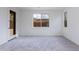 A bedroom with white walls, light carpet, a glass door and two windows at 17463 N 66Th Ave, Glendale, AZ 85308