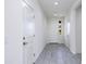 Bright hallway featuring neutral paint, gray tile flooring, and access to various rooms at 17463 N 66Th Ave, Glendale, AZ 85308
