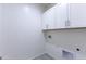 A laundry room with white cabinets, tile flooring, and utility hookups at 17463 N 66Th Ave, Glendale, AZ 85308