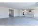 Bright, open-concept living room featuring gray tile floors and access to the kitchen and hallway at 17463 N 66Th Ave, Glendale, AZ 85308