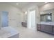 Elegant bathroom with double vanities, a soaking tub, and a tiled accent wall at 12297 E Troon Vista Dr # 255, Scottsdale, AZ 85255