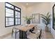 Dining room with wood table, modern chairs, and large black framed windows at 12297 E Troon Vista Dr # 255, Scottsdale, AZ 85255