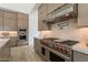 Gourmet kitchen featuring a professional-grade range, custom hood, and sleek cabinetry at 12297 E Troon Vista Dr # 255, Scottsdale, AZ 85255