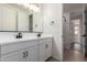 Bright bathroom featuring double vanity, white cabinetry, matte black hardware, and access to a tiled shower at 18450 E Camila Dr, Gold Canyon, AZ 85118