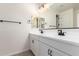 Bright bathroom featuring double vanity, white cabinetry, matte black hardware, and large mirror with Hollywood lighting at 18450 E Camila Dr, Gold Canyon, AZ 85118