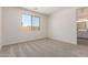 Comfortable bedroom featuring neutral carpet, a large window, and an ensuite bathroom providing a private retreat at 18450 E Camila Dr, Gold Canyon, AZ 85118