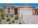 Welcoming home with tidy landscaping, paved driveway, a two-car garage and inviting front door at 18450 E Camila Dr, Gold Canyon, AZ 85118