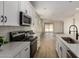 Open concept kitchen flows into the living room, featuring white cabinets, stainless steel appliances, and ample natural light at 18450 E Camila Dr, Gold Canyon, AZ 85118