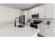 Bright kitchen featuring white cabinets, stainless steel appliances, and a modern matte black faucet with quartz countertops at 18450 E Camila Dr, Gold Canyon, AZ 85118