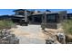 A contemporary home featuring a stone-paved driveway lined with desert landscaping and modern architectural details at 37445 N 104Th Pl, Scottsdale, AZ 85262