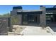 Modern home with a stone facade, a glass door entrance and desert landscaping at 37445 N 104Th Pl, Scottsdale, AZ 85262