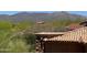 Tranquil landscape view with terracotta rooftops, lush desert vegetation, and distant mountain views at 37445 N 104Th Pl, Scottsdale, AZ 85262