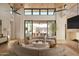 Open living room with curved sofa, fireplace, and view of backyard pool at 28119 N 109Th Way, Scottsdale, AZ 85262