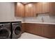 Modern laundry room with wood cabinets and quartz countertops at 28101 N 109Th Way, Scottsdale, AZ 85262