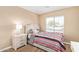 Cozy bedroom features a comfortable bed with a patterned comforter and a bright window bringing in natural light at 9143 W Harmony Ln, Peoria, AZ 85382