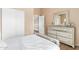 Bedroom with a large dresser, closet, and light hardwood flooring, creating a peaceful and inviting atmosphere at 9143 W Harmony Ln, Peoria, AZ 85382