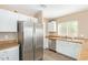 Well-lit kitchen showcasing stainless steel appliances, white cabinets and a sink beneath the window at 9143 W Harmony Ln, Peoria, AZ 85382