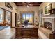 Luxurious home office features a fireplace, built-in desk, and scenic views at 26761 N 98Th Way, Scottsdale, AZ 85262