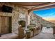 Relaxing stone patio with fireplace, seating area, and mountain views at 26761 N 98Th Way, Scottsdale, AZ 85262