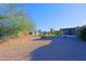 Large backyard with gravel landscaping, mature trees, and a partially visible home at 17407 N 130Th Dr, Sun City West, AZ 85375