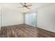 Open bedroom featuring wood flooring, ceiling fan, and sliding glass door at 1673 W Hazelwood St, Phoenix, AZ 85015