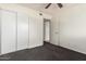 This bedroom features a ceiling fan, closet, and neutral walls and carpet at 1673 W Hazelwood St, Phoenix, AZ 85015