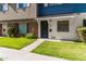Attractive townhome exhibiting a beautiful front lawn that guides you to the striking black front door at 1673 W Hazelwood St, Phoenix, AZ 85015