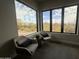 Cozy sitting area with two chairs and a side table with desert views through large windows at 3525 S Kings Ranch Ct # 4, Gold Canyon, AZ 85118