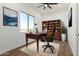 Bright home office features a wood desk, built-in shelving, and views from the large window at 31712 N 169Th Ave, Surprise, AZ 85387