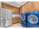 Laundry room with stainless steel appliances and wood cabinets at 9025 N Flying Butte --, Fountain Hills, AZ 85268