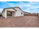 The back exterior of the home features a covered patio, dirt backyard, and block wall perimeter at 18795 E Elizar Dr, Gold Canyon, AZ 85118