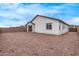 Back exterior of the home featuring a dirt yard, block wall, and covered patio area for relaxation at 18795 E Elizar Dr, Gold Canyon, AZ 85118