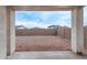 A spacious dirt backyard enclosed by a block wall with a covered patio area for entertaining at 18795 E Elizar Dr, Gold Canyon, AZ 85118
