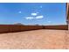 Expansive dirt backyard surrounded by a tall brick fence, offering privacy and potential for customization at 18507 E Camila Dr, Gold Canyon, AZ 85118
