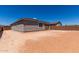 View of the backyard featuring a blank slate of dirt surrounded by a brick fence and the house's stucco exterior at 18507 E Camila Dr, Gold Canyon, AZ 85118